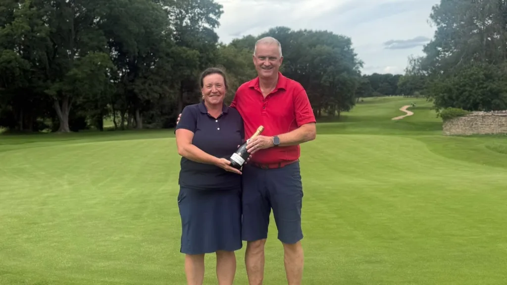 Aude Cazenave celebrates the successful completion of her 180-hole marathon challenge alongside Frilford Heath Men’s Captain, Tony Weir.